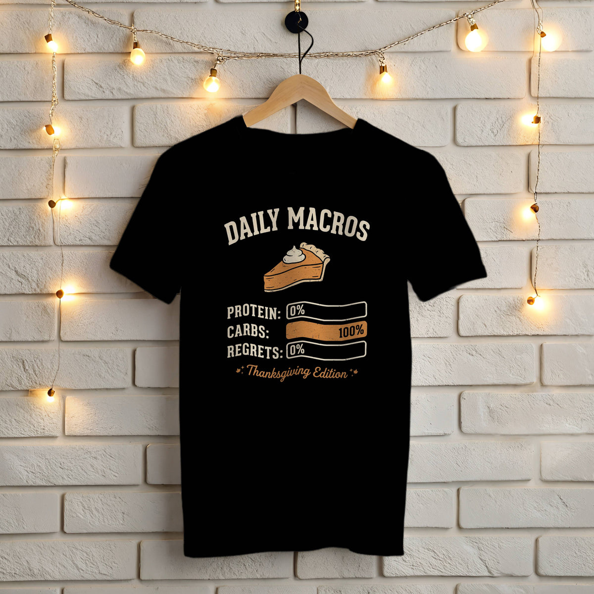 Black Gildan 5000 t-shirt with funny Daily Macros Thanksgiving Edition design: protein 0%, carbs 100%, regrets 0% and a pumpkin pie slice