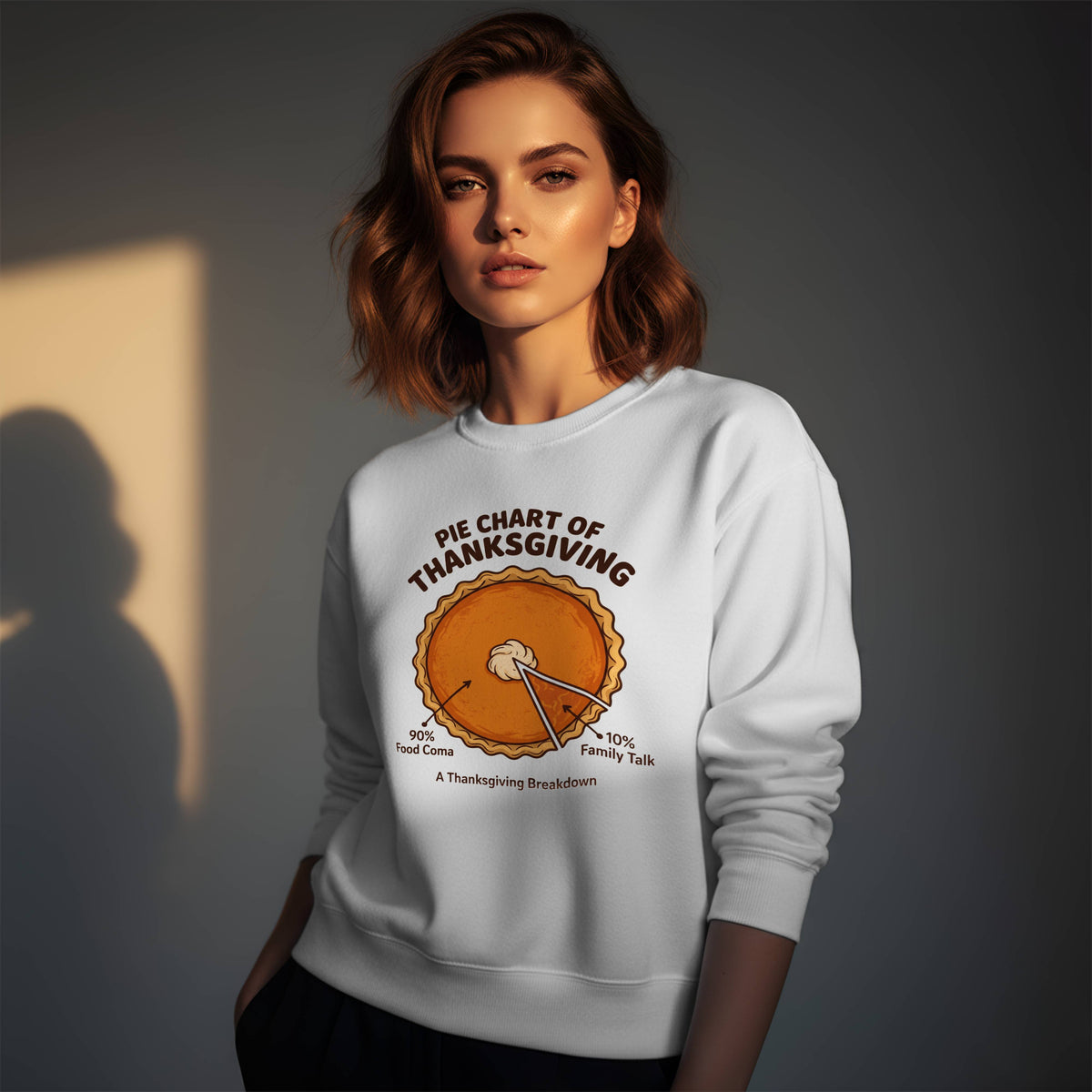 Woman wearing a white Gildan 18000 crewneck sweatshirt with funny Pie Chart of Thanksgiving pumpkin pie design, 90% food coma and 10% family talk