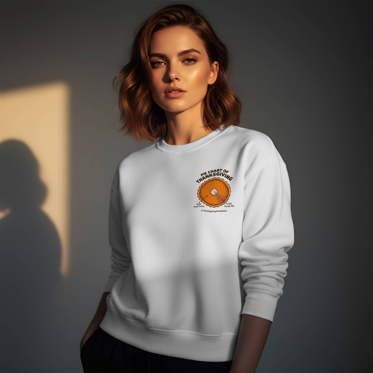 Woman wearing a white Gildan 18000 crewneck sweatshirt with small left chest Pie Chart of Thanksgiving pumpkin pie print