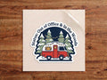Status: Out of Office & In the Woods sticker – red camper with string lights under snowy pine trees