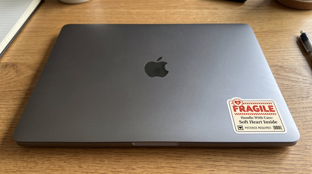 Fragile Soft Heart Inside waterproof sticker on the corner of a gray laptop lid