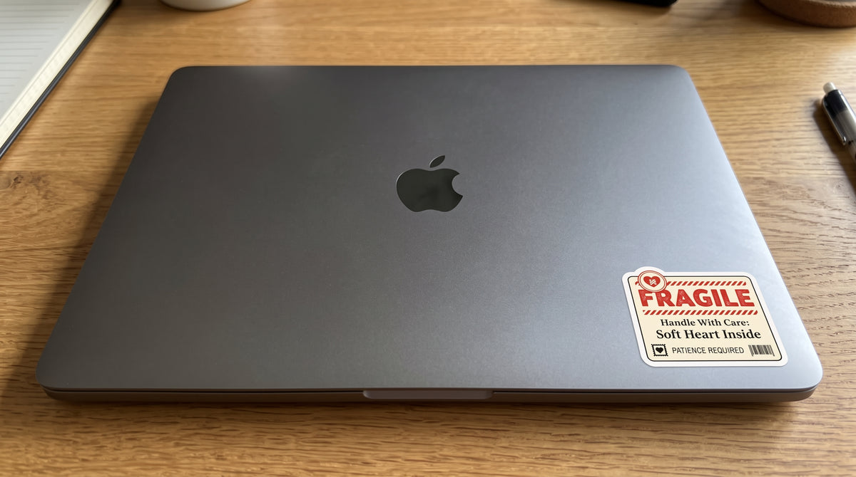 Fragile Soft Heart Inside sticker from the Protect Your Peace bundle on the corner of a gray laptop lid