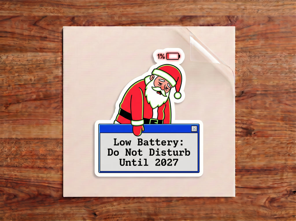 Low Battery Do Not Disturb Until 2027 sticker – tired Santa at 1% battery leaning on a retro computer pop-up window