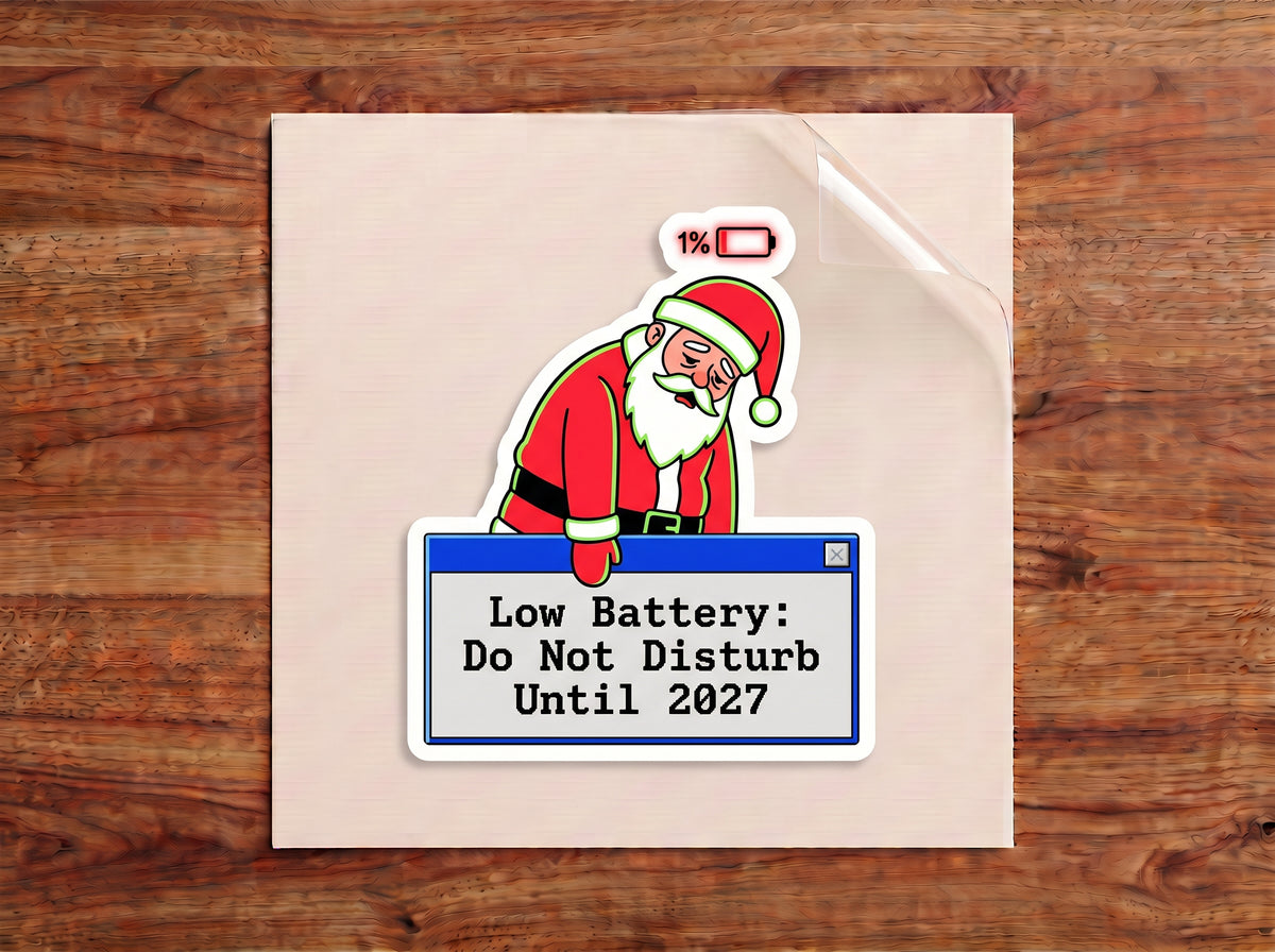 Low Battery Do Not Disturb Until 2027 sticker – tired Santa at 1% battery leaning on a retro computer pop-up window