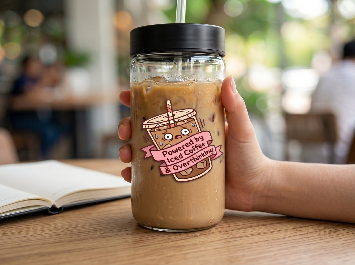Powered by Iced Coffee & Overthinking waterproof sticker on a glass iced coffee cup at a cafe