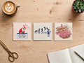 Running on Empty sticker bundle – Low Battery Santa, Mon to Fri Gamer and Iced Coffee Overthinking stickers side by side on a wooden desk